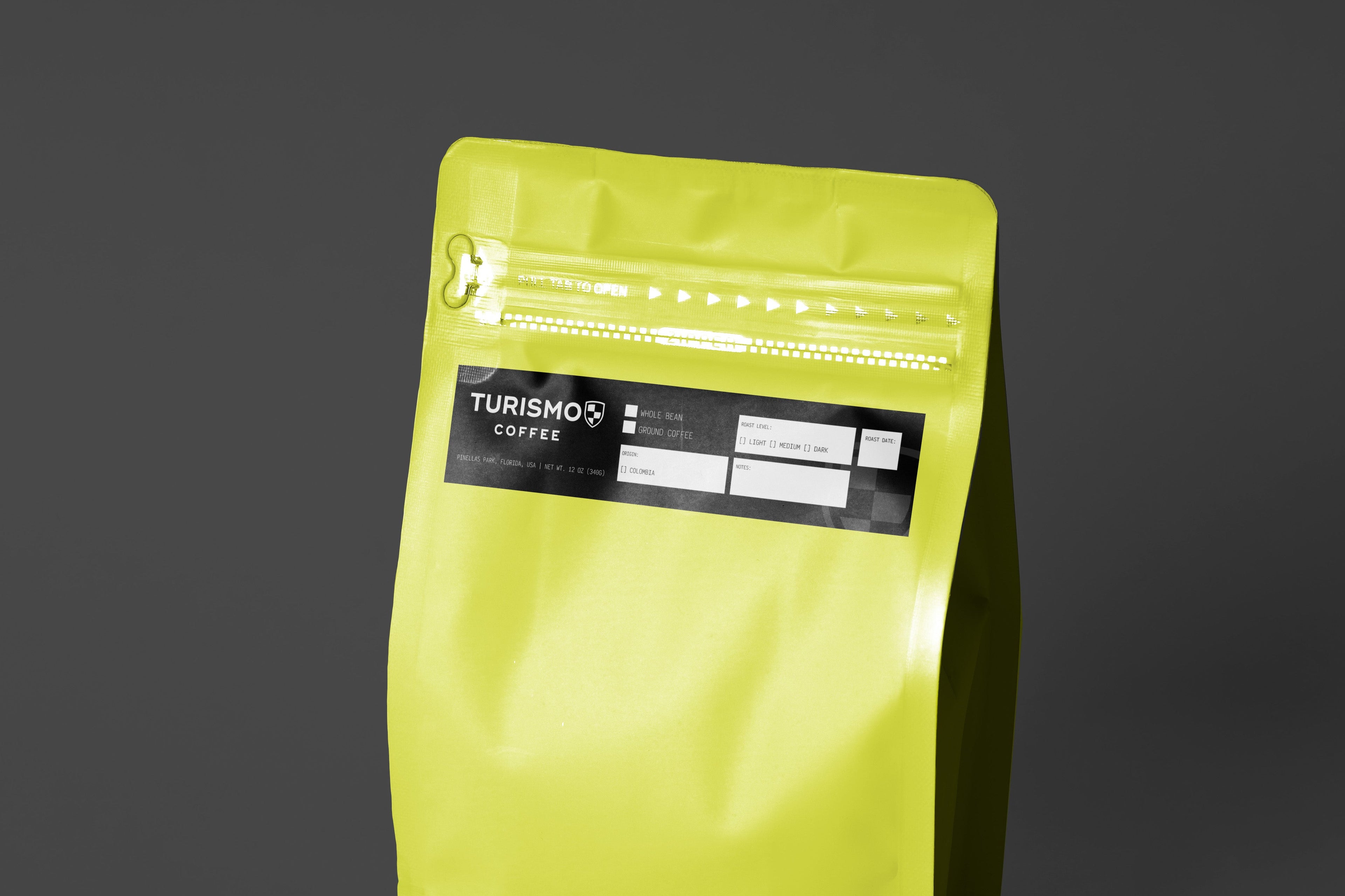 Yellow coffee bag with a label on a dark gray background

